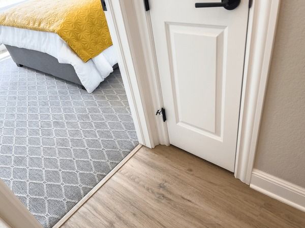 Närbild på en modern vit innerdörr med svarta detaljer monterad i en dörrkarm.